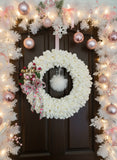 Decorative wreath with white foam base and festive decorations on a dark surface