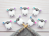 Sheep-shaped knitting needles with colorful yarn on a wooden surface