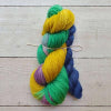 Two skeins of colourful yarn tied together on a wooden surface