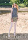 Woman wearing a cable knit sweater by Akiko Louisa Harding on a natural background