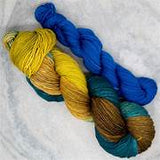 Three skeins of yarn in blue, yellow, and green on a white background